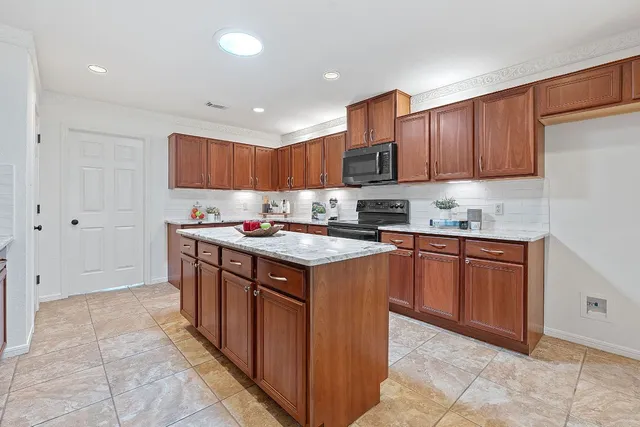 a kitchen with granite countertop wood cabinets and stainless steel appliances