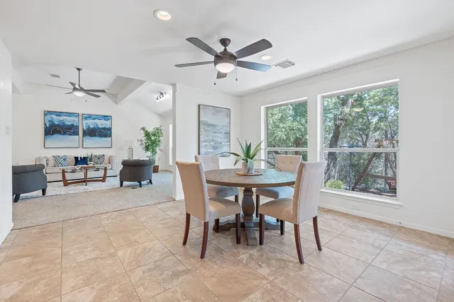 a dining room with wooden floor and a floor to ceiling window
