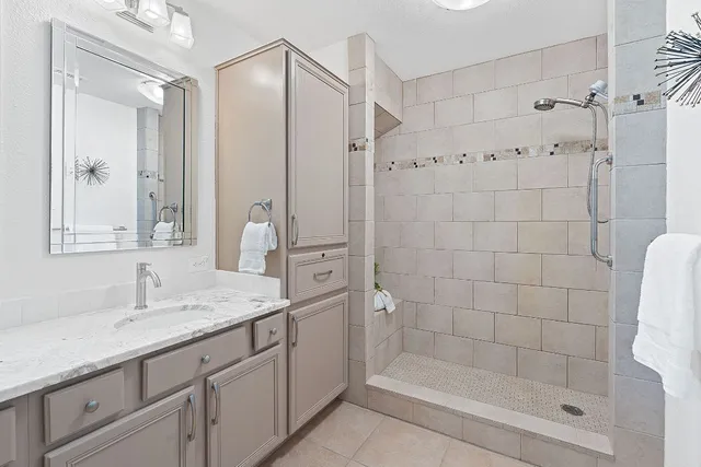 a bedroom with a bed painting on wall and a large window