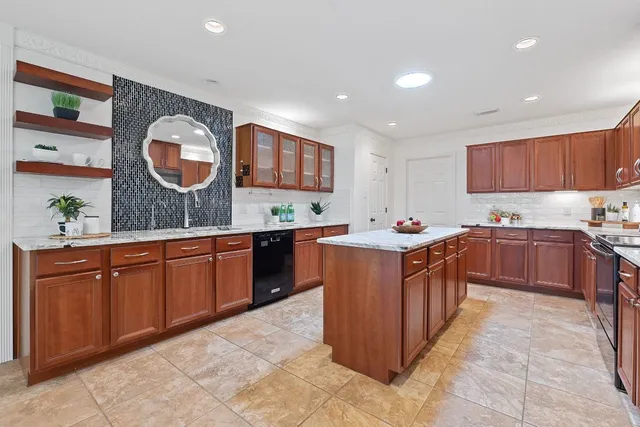 a kitchen with stainless steel appliances granite countertop a stove a sink and a refrigerator