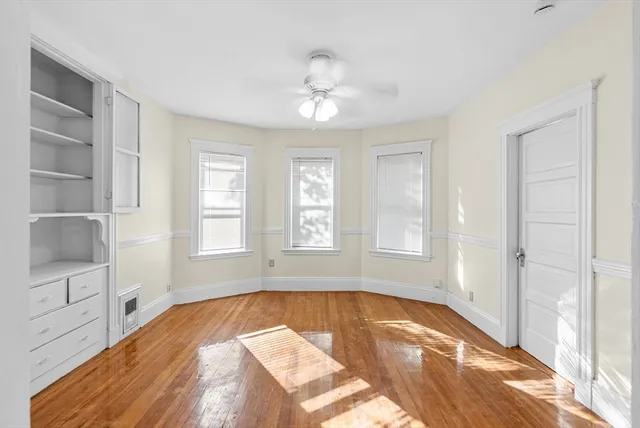 a kitchen with cabinets wooden floor and stainless steel appliances