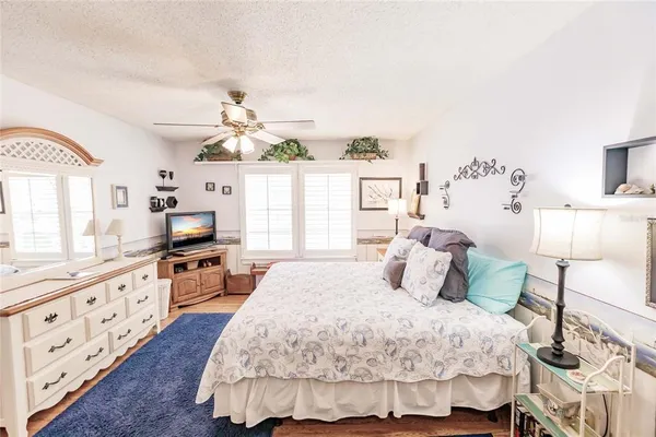 a bed room with a bed mirror and a chair