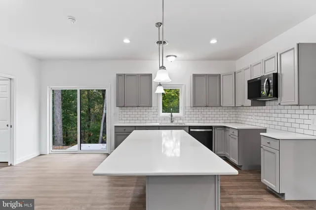 a large kitchen with kitchen island a sink stainless steel appliances and cabinets