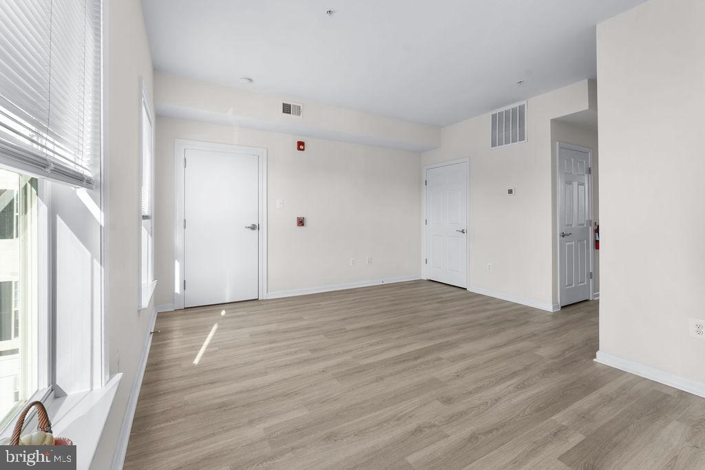 3542 Worthington Boulevard, Unit 301 Frederick, MD 21704 - Photo 11 of 22 a view of an empty room with wooden floor and a window