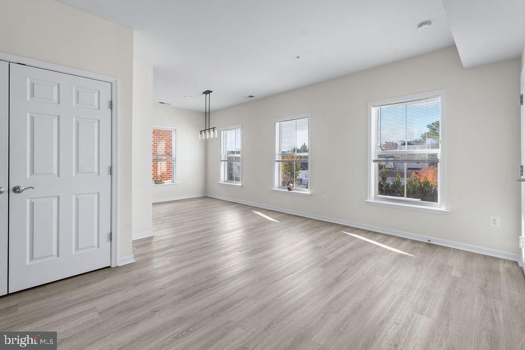 3542 Worthington Boulevard, Unit 301 Frederick, MD 21704 - Photo 12 of 22 an empty room with wooden floor and windows