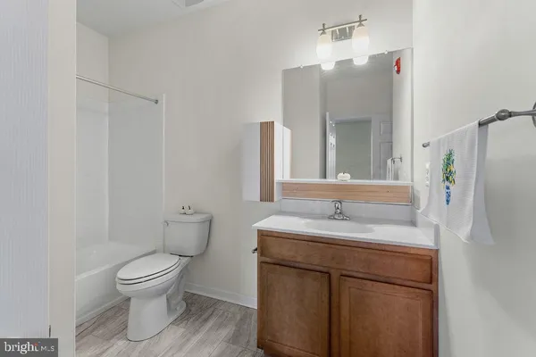 a bathroom with a granite countertop toilet sink and mirror