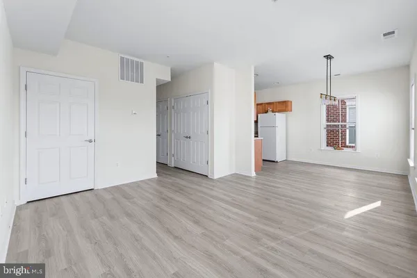 a view of empty room with wooden floor and window
