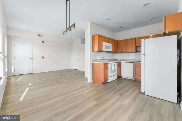a view of a kitchen with wooden floor and a ceiling fan
