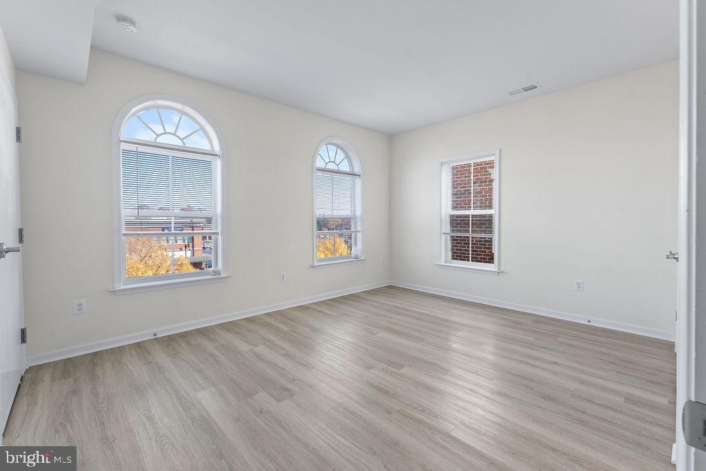 3542 Worthington Boulevard, Unit 301 Frederick, MD 21704 - Photo 10 of 22 a view of an empty room with wooden floor and a window