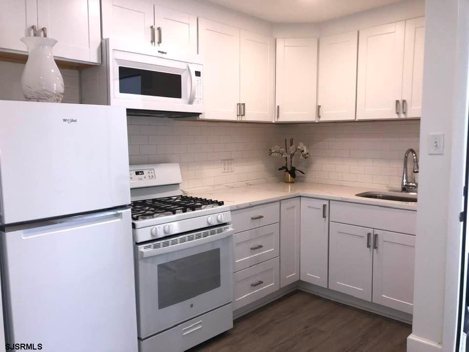 a kitchen with stainless steel appliances granite countertop white cabinets a sink and dishwasher