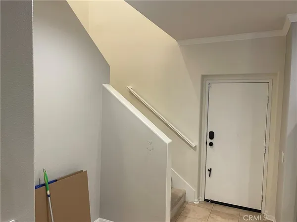 a view of staircase with white walls and white door