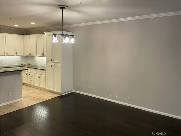 a kitchen with stainless steel appliances granite countertop a sink a stove and a refrigerator with wooden floor