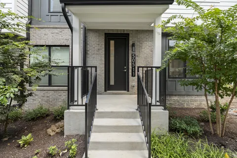 a front view of a house with a tree in front