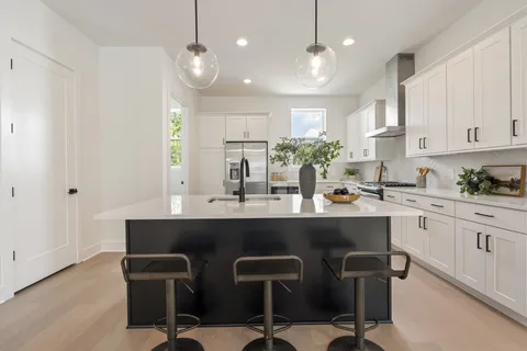 a kitchen with a table chairs sink and cabinets