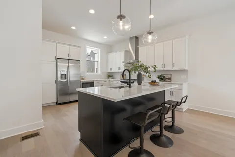 a kitchen with kitchen island a sink dining table and chairs