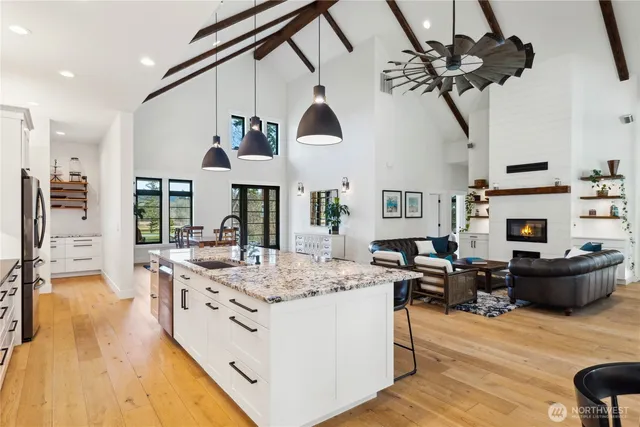 a view of living room kitchen with stainless steel appliances granite countertop furniture and a fireplace