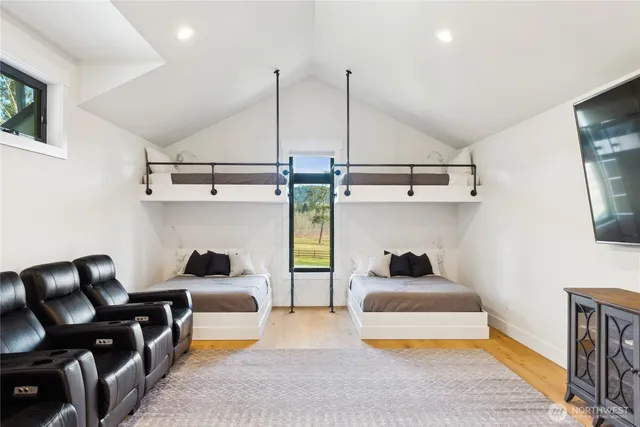 a bedroom with a bed a flat screen tv and windows