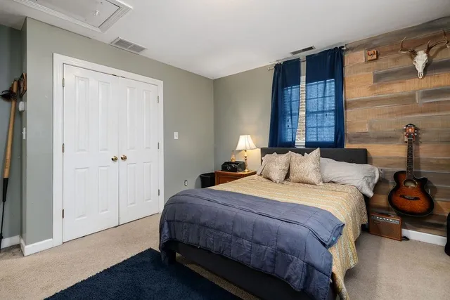 an empty room with wooden floor closet and windows