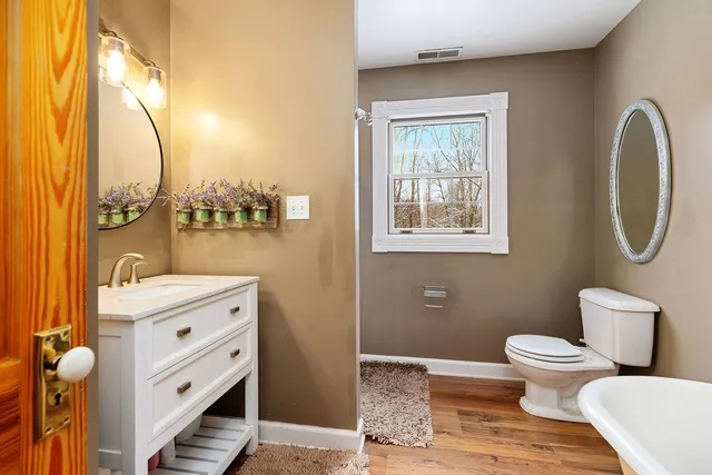 a view of a bathroom with wooden floor and a bathroom