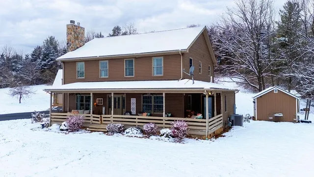 a view of a house with a yard and large tree