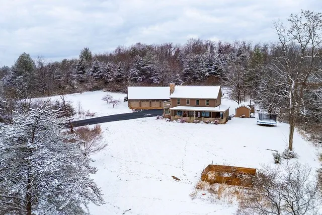 a front view of a house with a yard covered in snow