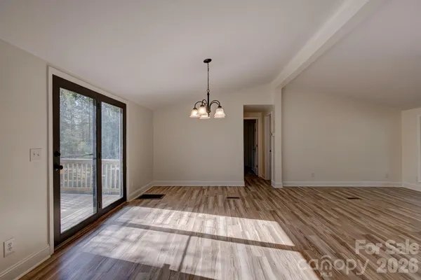 a view of a room with wooden floor ceiling fan and window