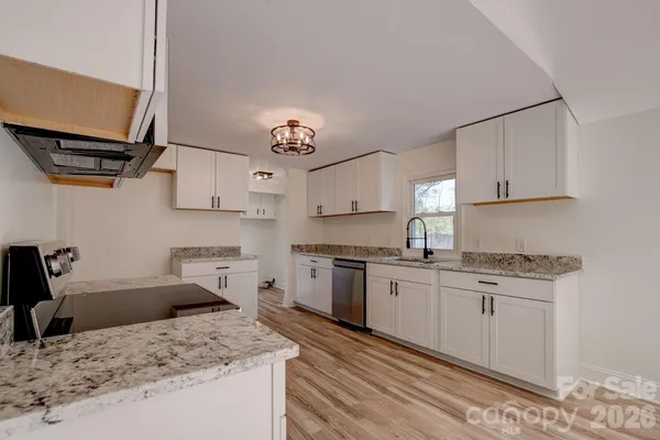 a kitchen with a stove sink and cabinets