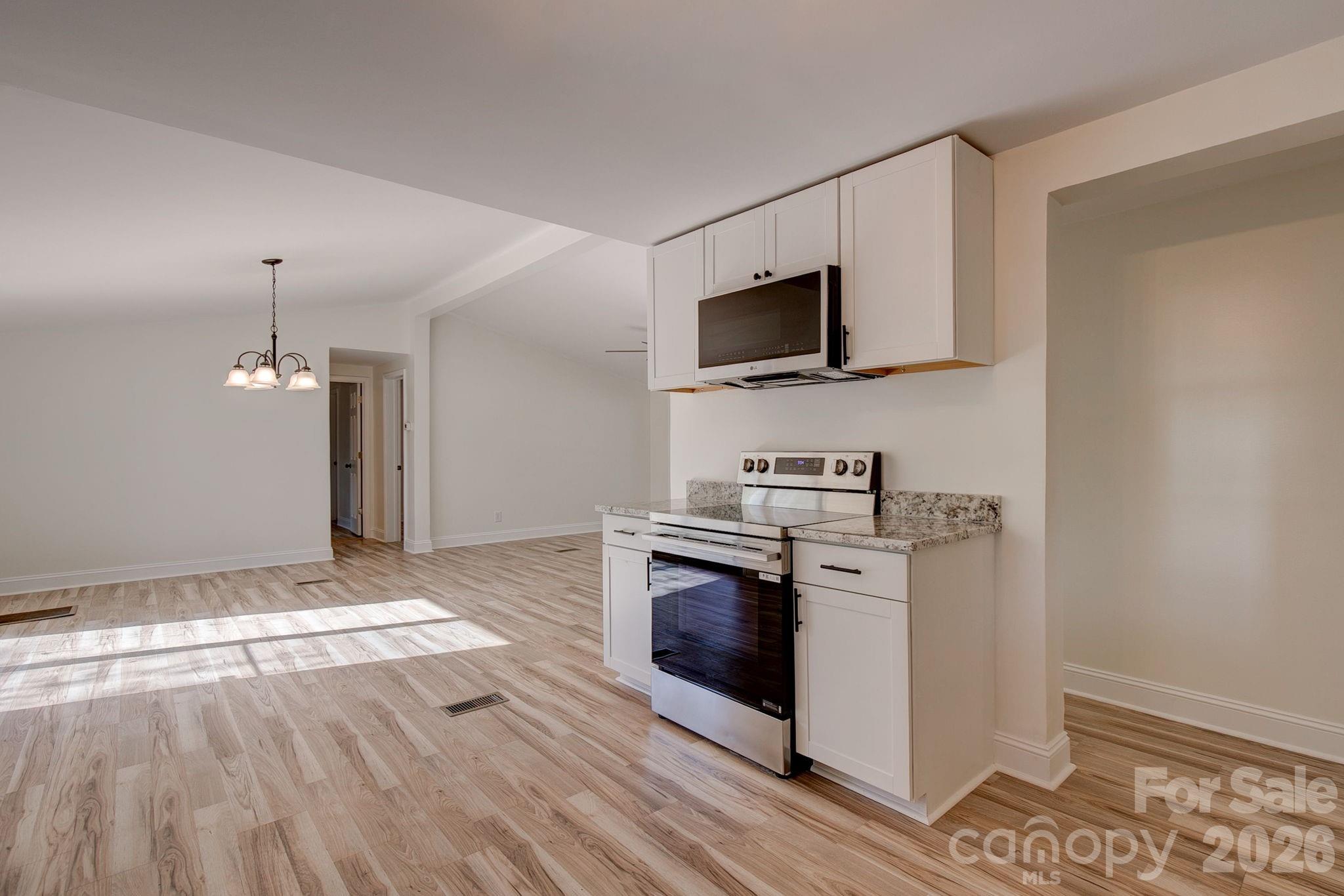 4282 Fred Gardner Road Kershaw, SC 29067 - Photo 16 of 36 a kitchen with stainless steel appliances granite countertop a stove and a microwave