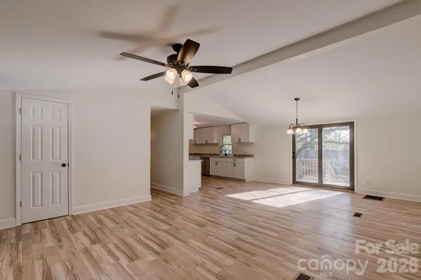 a view of a kitchen with wooden floor and a ceiling fan