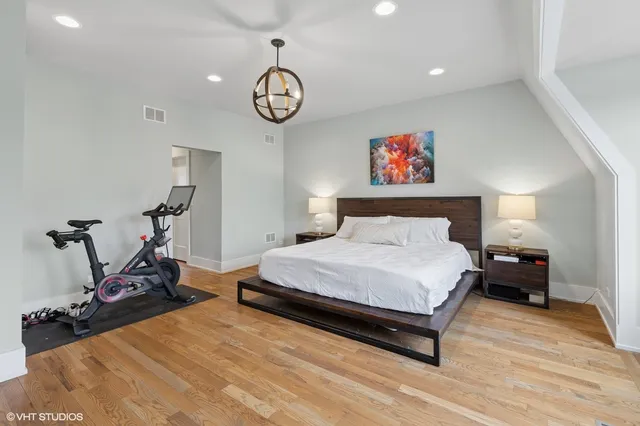 a spacious bedroom with a bed and a chair