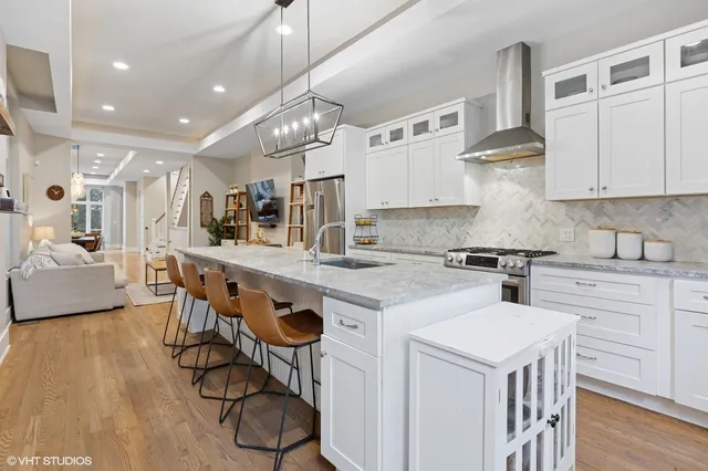 a kitchen that has a lot of cabinets in it and wooden floors