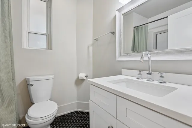 a bathroom with a sink a toilet and a mirror