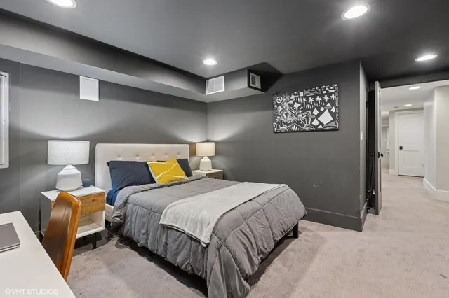 a bedroom with a bed and painting on the wall