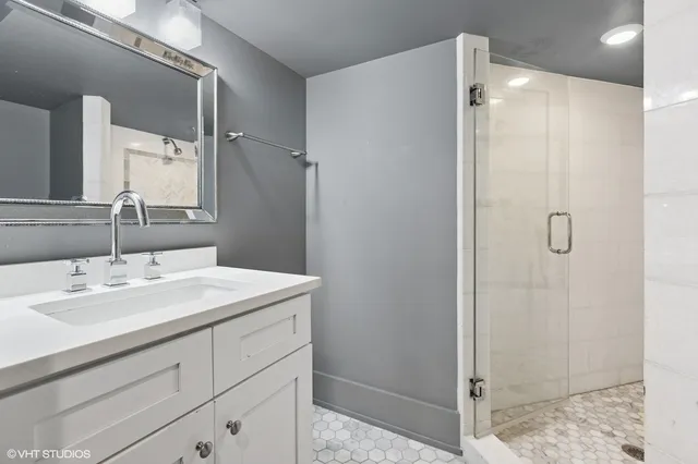 a bathroom with a sink shower and a mirror
