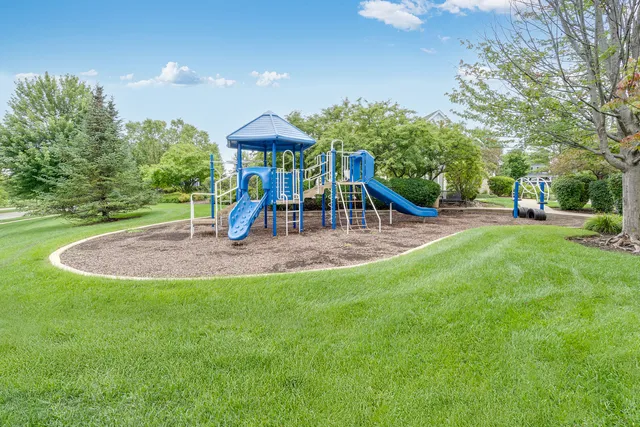 a view of outdoor space with playground and green space