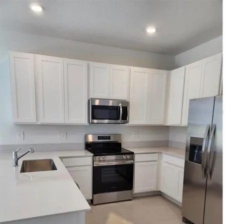 a kitchen with white cabinets and stainless steel appliances