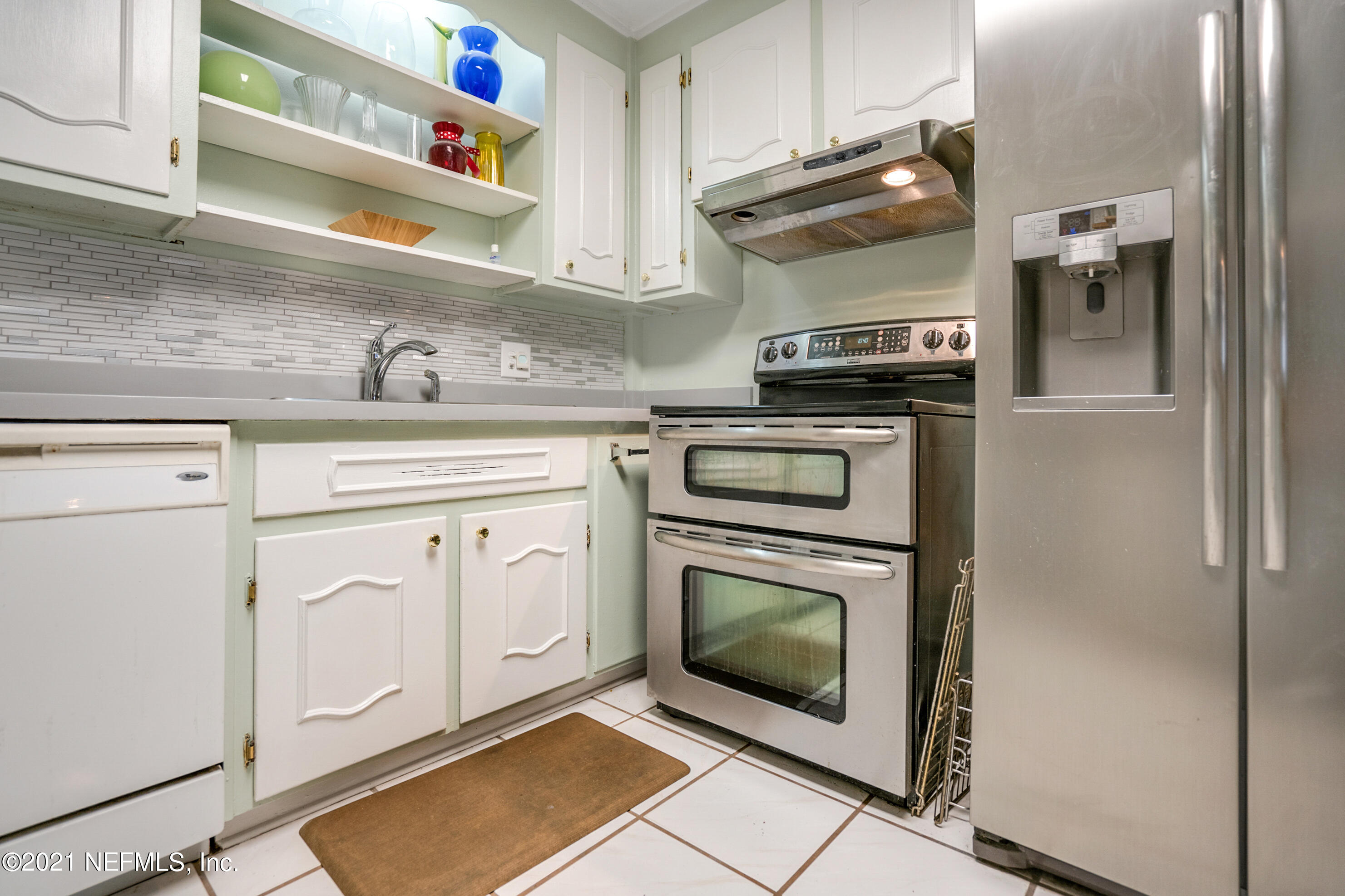 4004 Rogero Road Jacksonville, FL 32277 - Photo 8 of 19 a kitchen with white cabinets and appliances