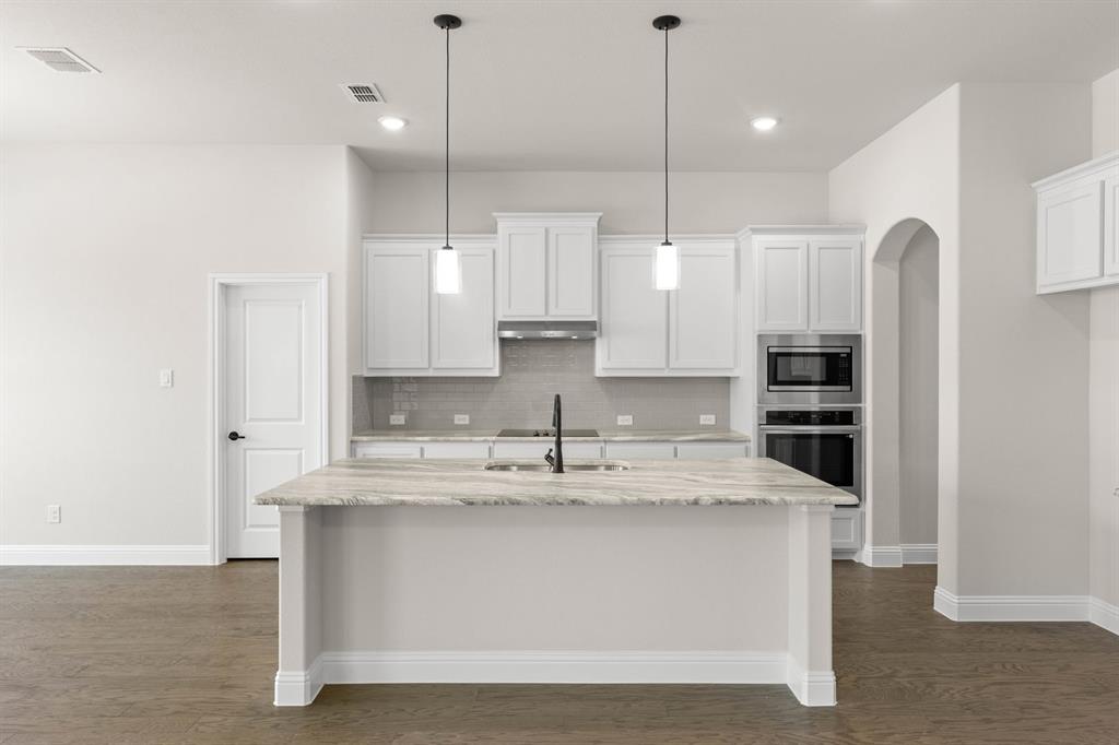 35 Magpie Street Joshua, TX 76058 - Photo 3 of 19 a large kitchen with stainless steel appliances kitchen island a large counter space a sink and cabinets