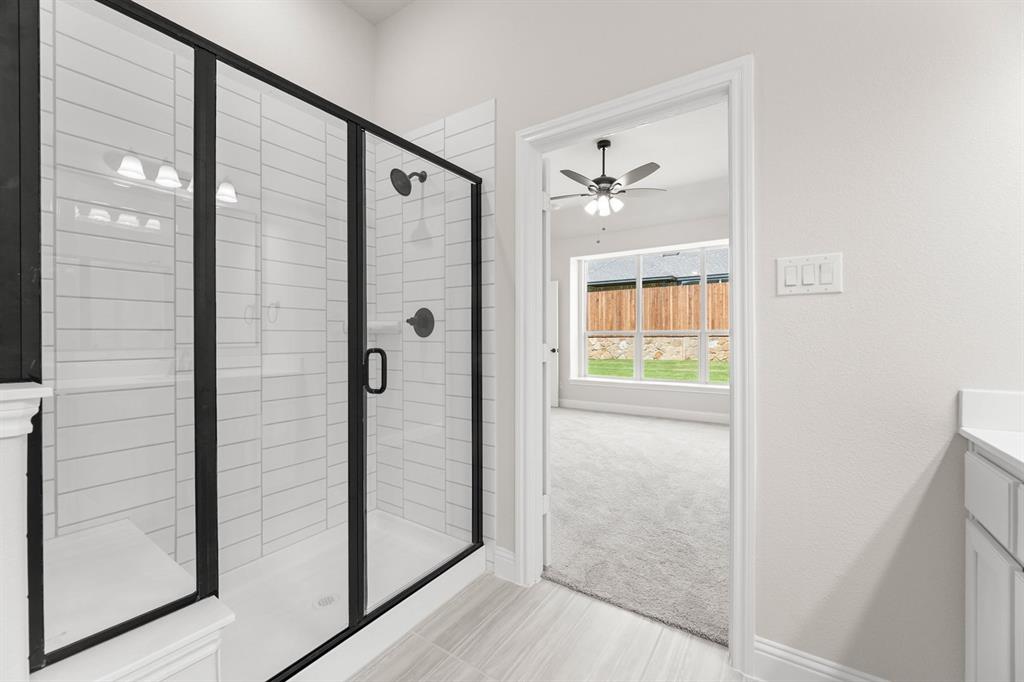 35 Magpie Street Joshua, TX 76058 - Photo 10 of 19 a bathroom with a glass shower door and a window