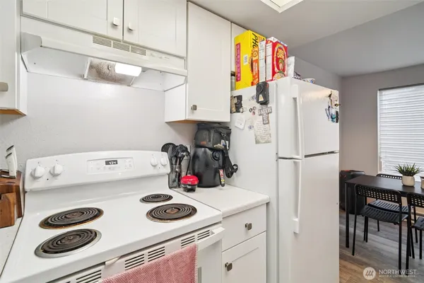 a kitchen with a refrigerator and a stove top oven