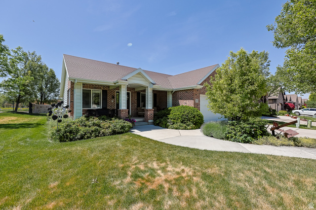 31 Village Square Road Centerville, UT 84014 - Photo 2 of 29 Brick and siding exterior featuring a covered entry, attached garage, and mature landscaping
