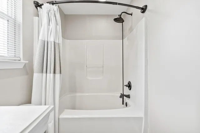 a bathroom with a bathtub and shower