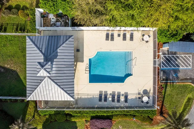 an aerial view of a houses with an outdoor space and seating