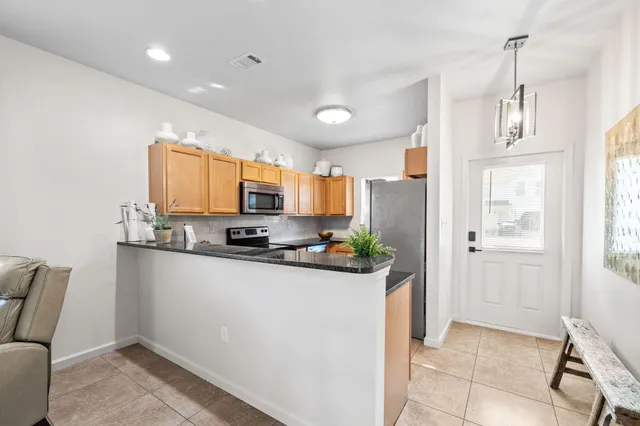 a kitchen with stainless steel appliances granite countertop a refrigerator and a stove top oven