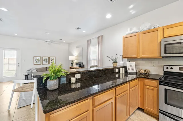 a kitchen with stainless steel appliances granite countertop sink a stove a microwave a counter top space and cabinets