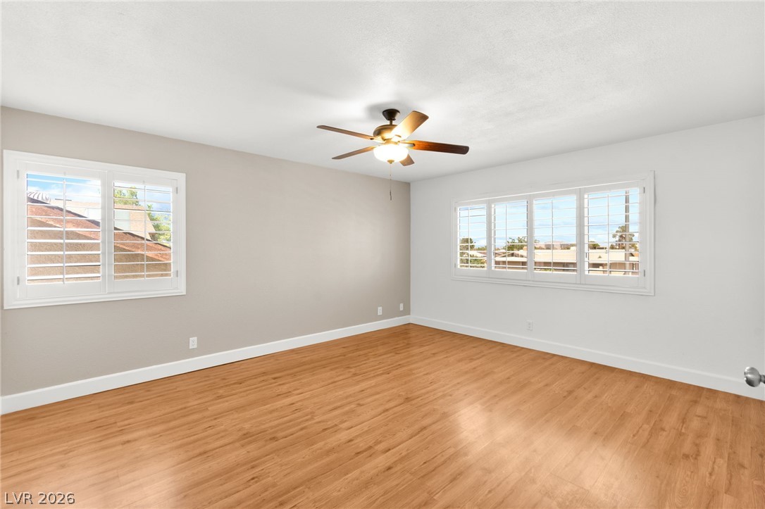 4430 Cranbrook Way Las Vegas, NV 89103 - Photo 35 of 50 A well-lit bedroom features pristine wood flooring and a classic ceiling fan.