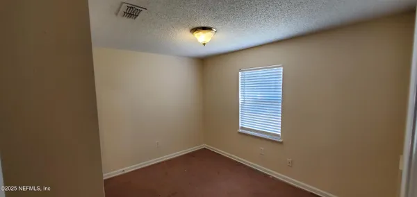 an empty room with windows and closet