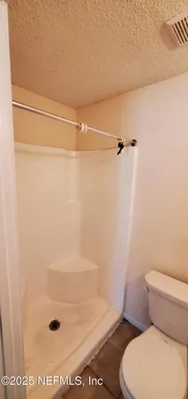 a bathroom with a toilet and a shower