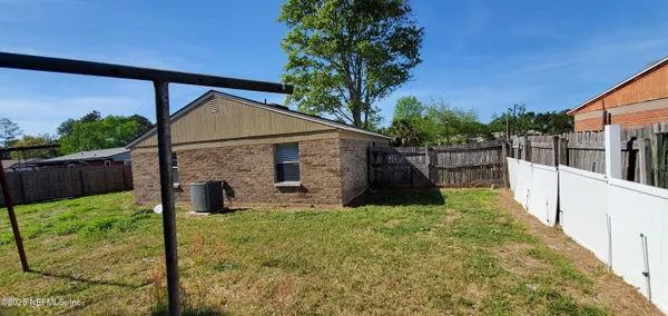 a view of a house with backyard and a tree