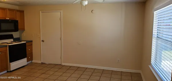 a view of an empty room and staircase with wooden floor